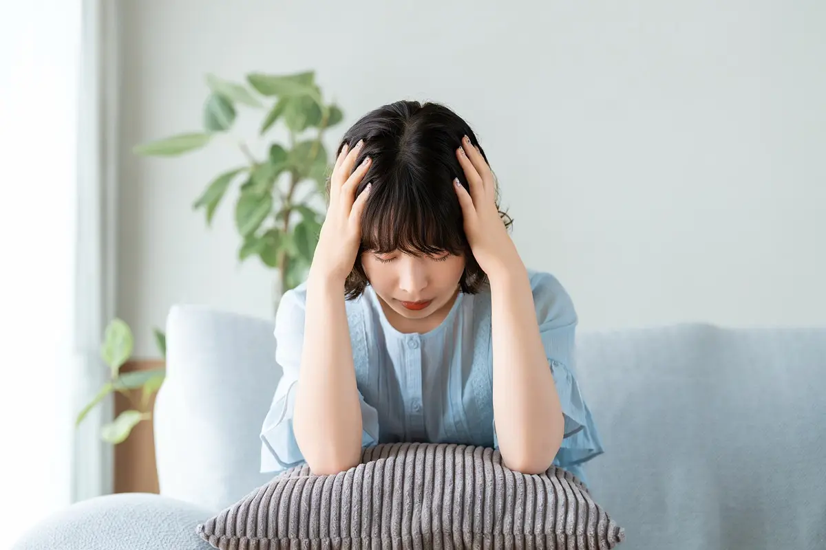 上の階の物音に悩み、頭を抱える女性